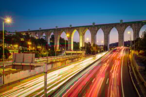 Cityscape at dusk - highway traffic near Campolide station car lights trails. Lisbon, Portugal