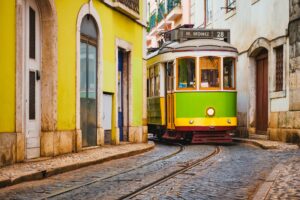 Famous vintage yellow tram 28 in the narrow streets of Alfama district in Lisbon, Portugal
